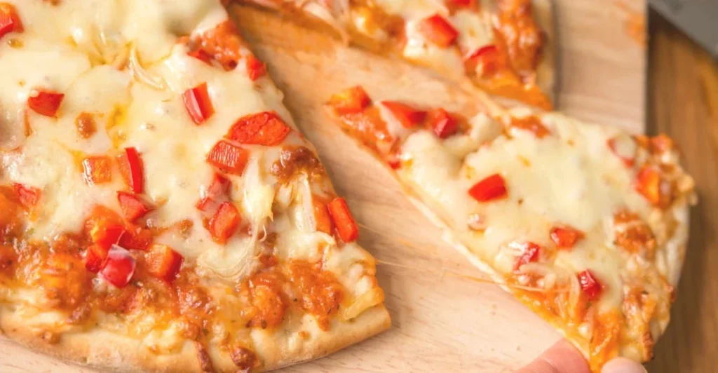 Fatias de pizza caseira com uma cobertura generosa de queijo vegano branco derretido e borbulhante